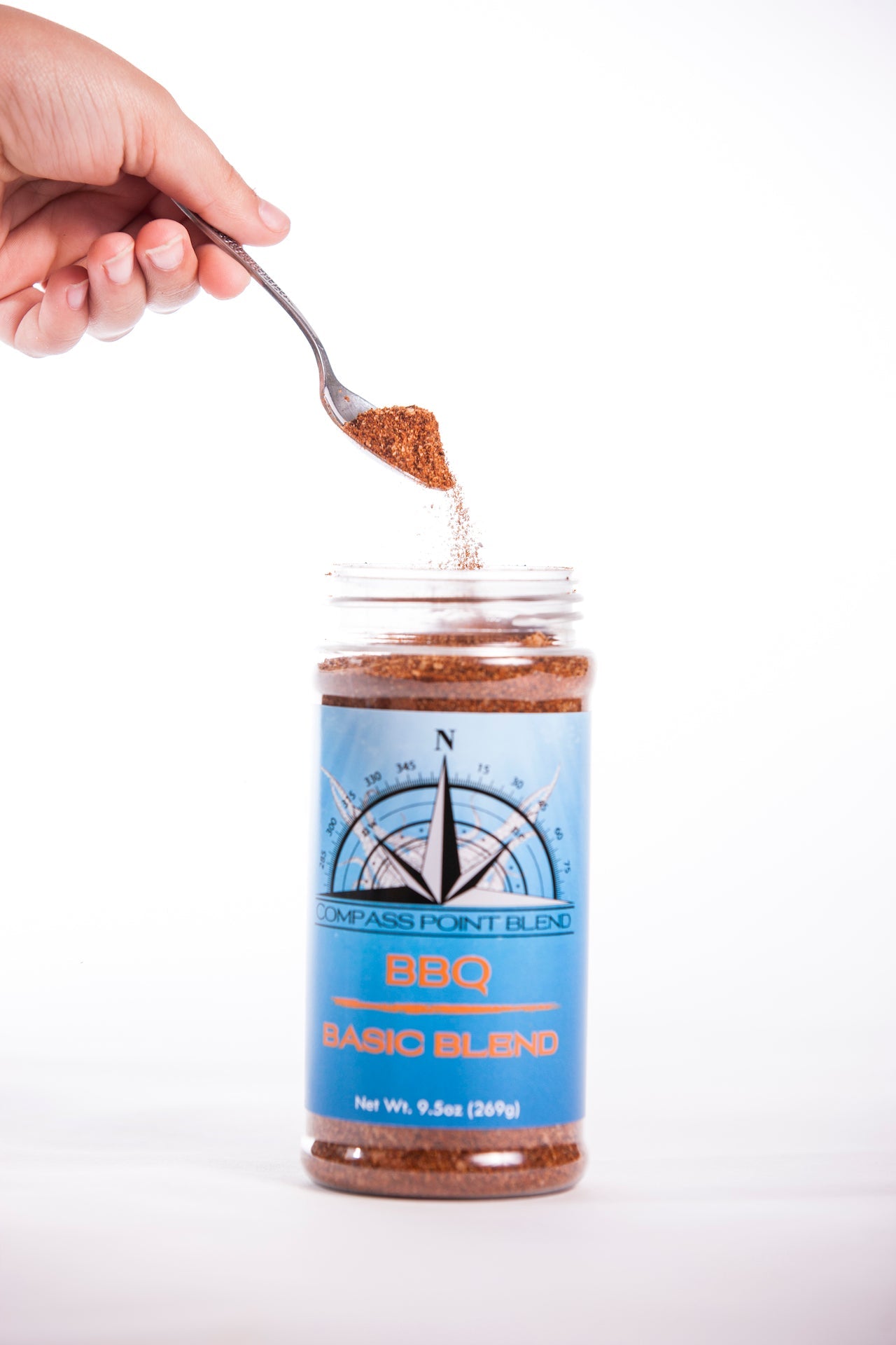 Compass Point Blend BBQ Blend being poured from a spoon into jar. BBQ seasoning spice blend, basic blend, 9.5oz jar
