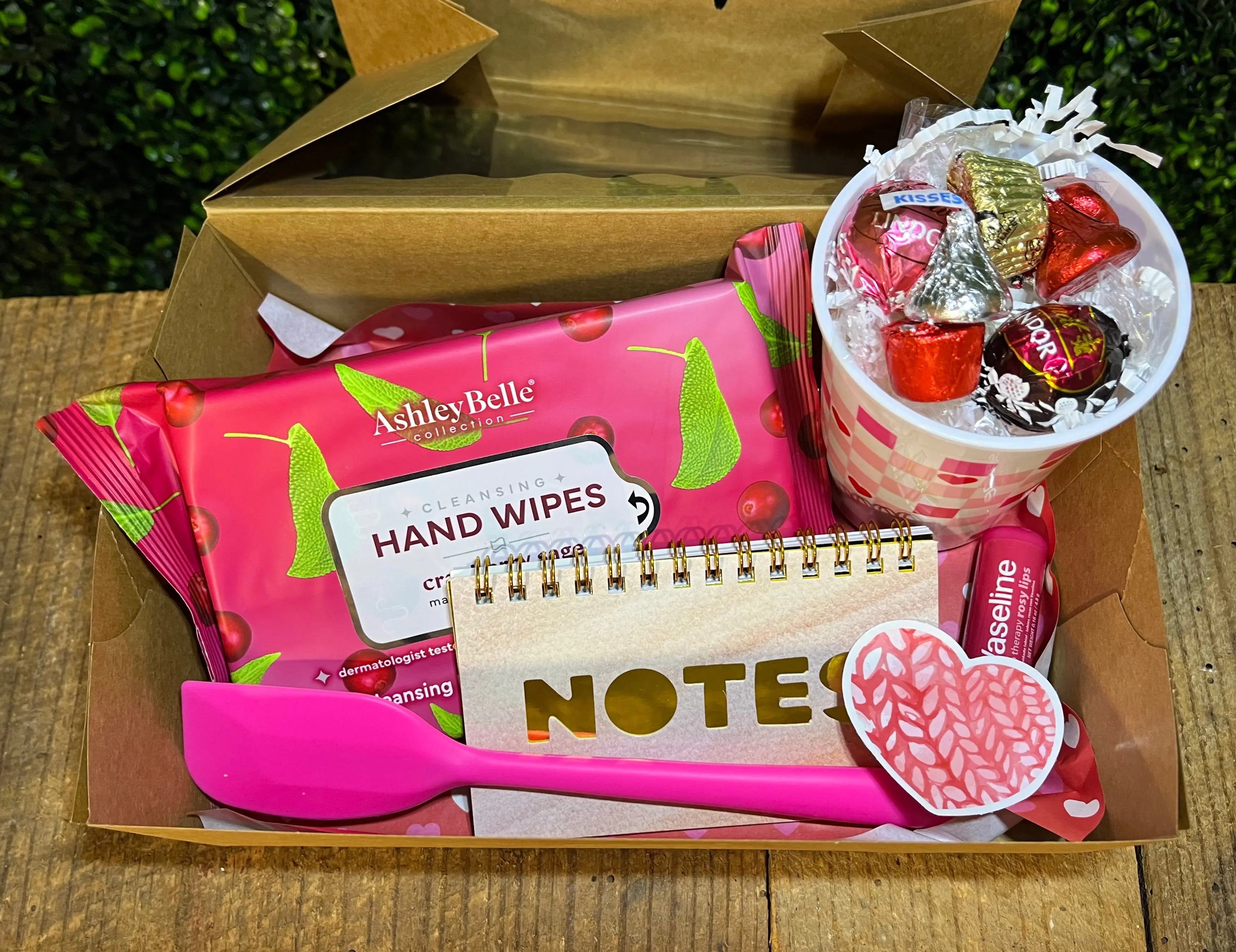 Valentine's Day gift box: hand wipes, notepad, pink spatula, lip balm & candy cup. "Main Street Collective's 'A Bit of Everything' box"