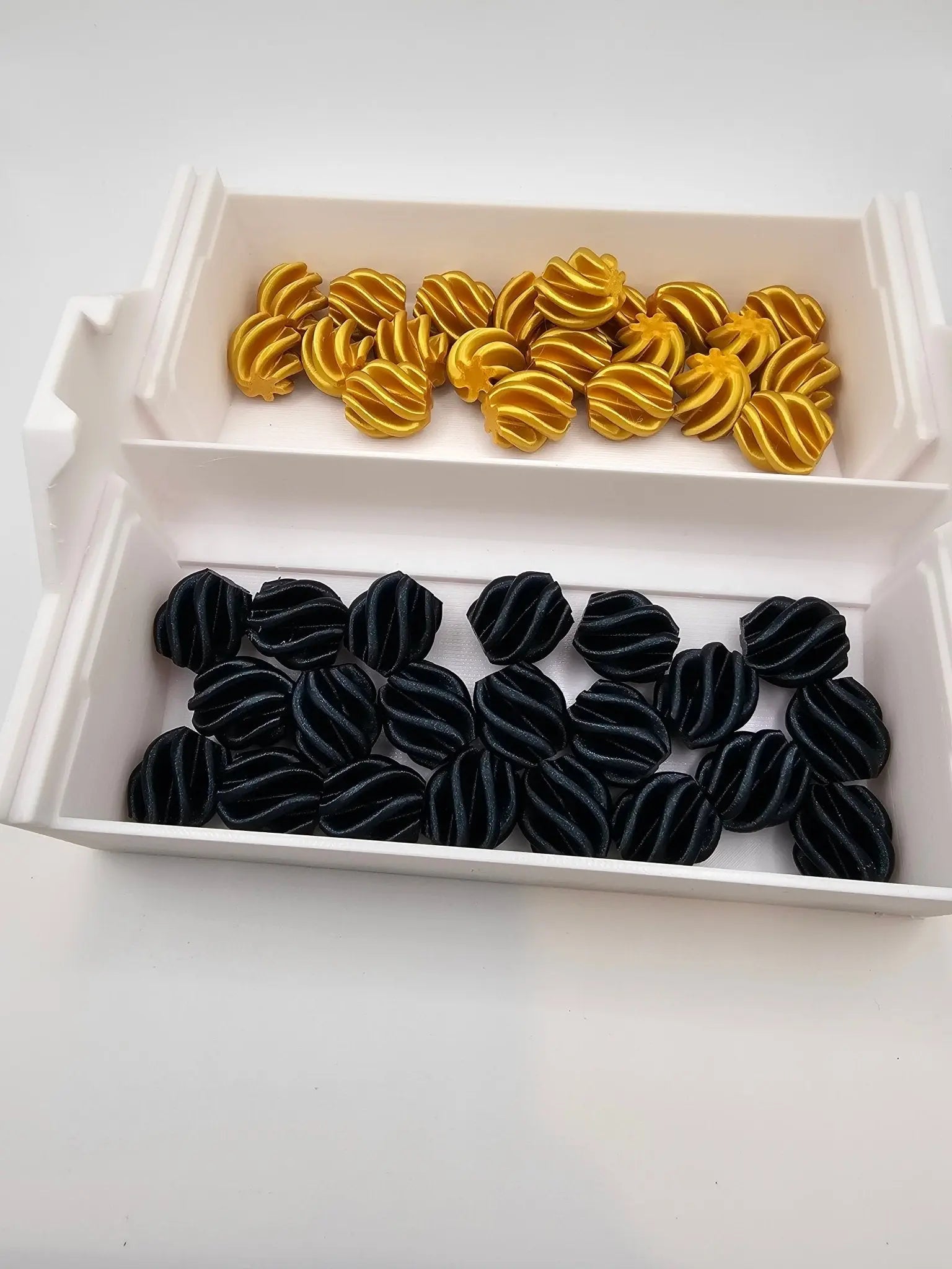 Cascading Self-Sorting Connect 4 game by Main Street Collective: 3D printed, gold & black pieces, self-sorting trays.