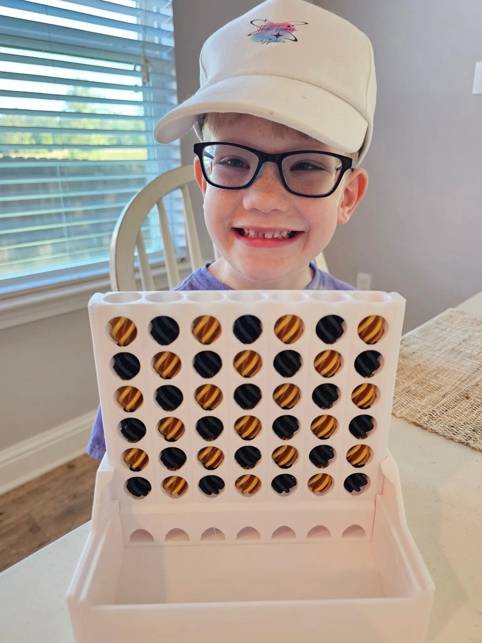 Kid with Self-Sorting Connect Four Game: Gold & Black Discs, Fun & Educational!