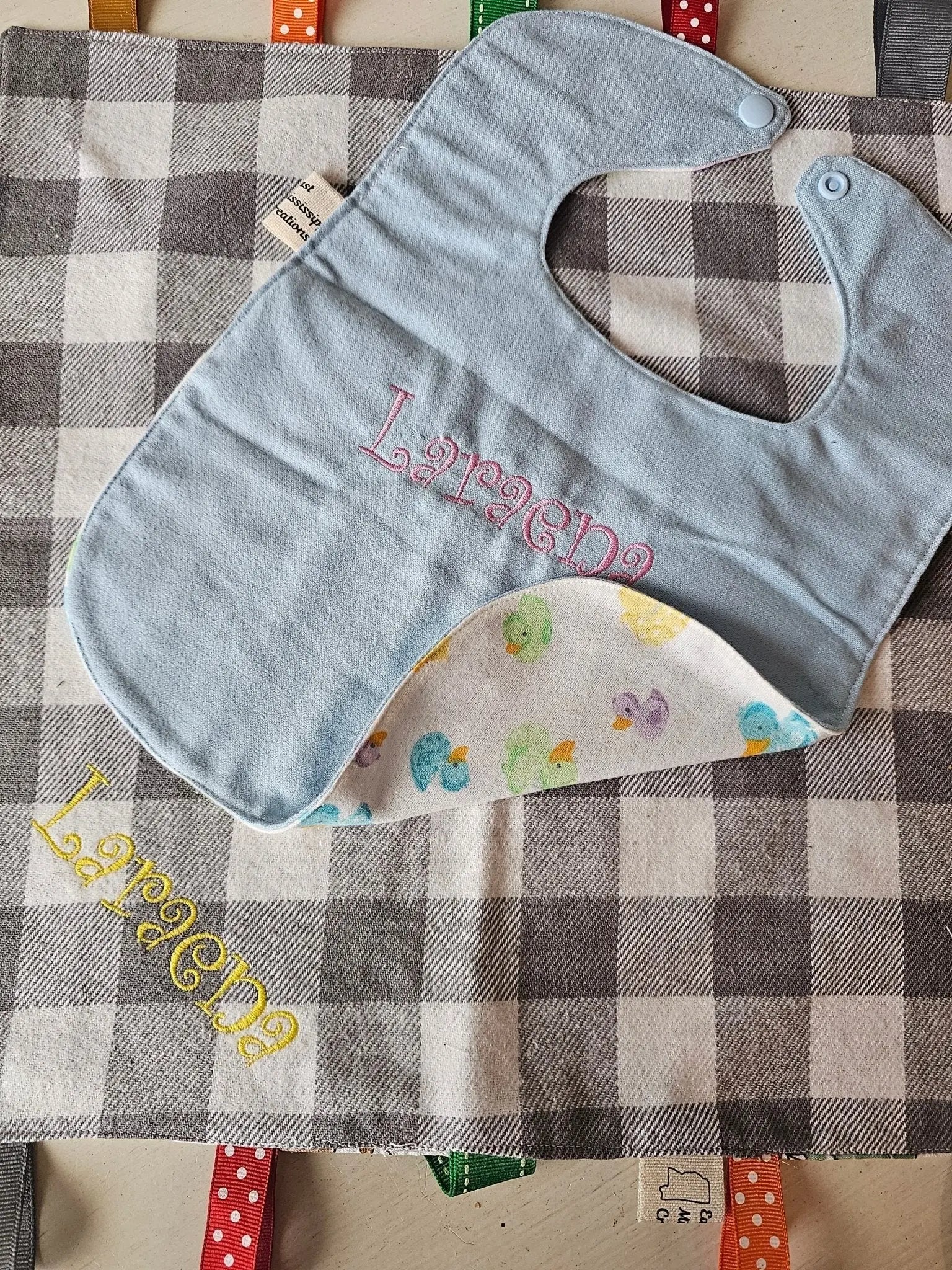 Personalized Handmade Baby Bib: Blue cotton flannel bib with "Larena" name embroidered on, duck print lining, East Mississippi Creations.