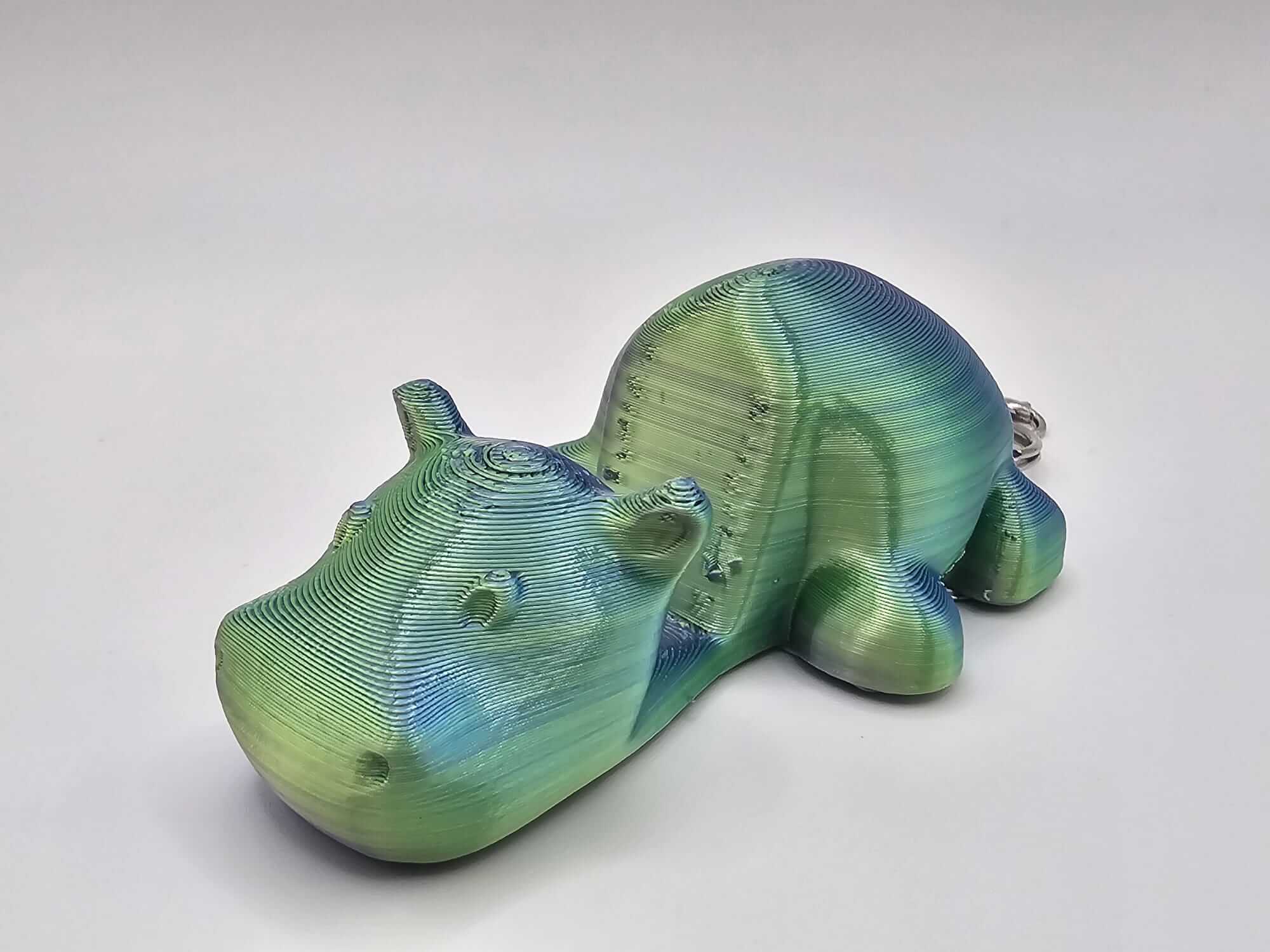Hippo Helper Phone Holder Keychain by The Tween Space clipped to backpack and resting on desk – Mississippi handmade gifts