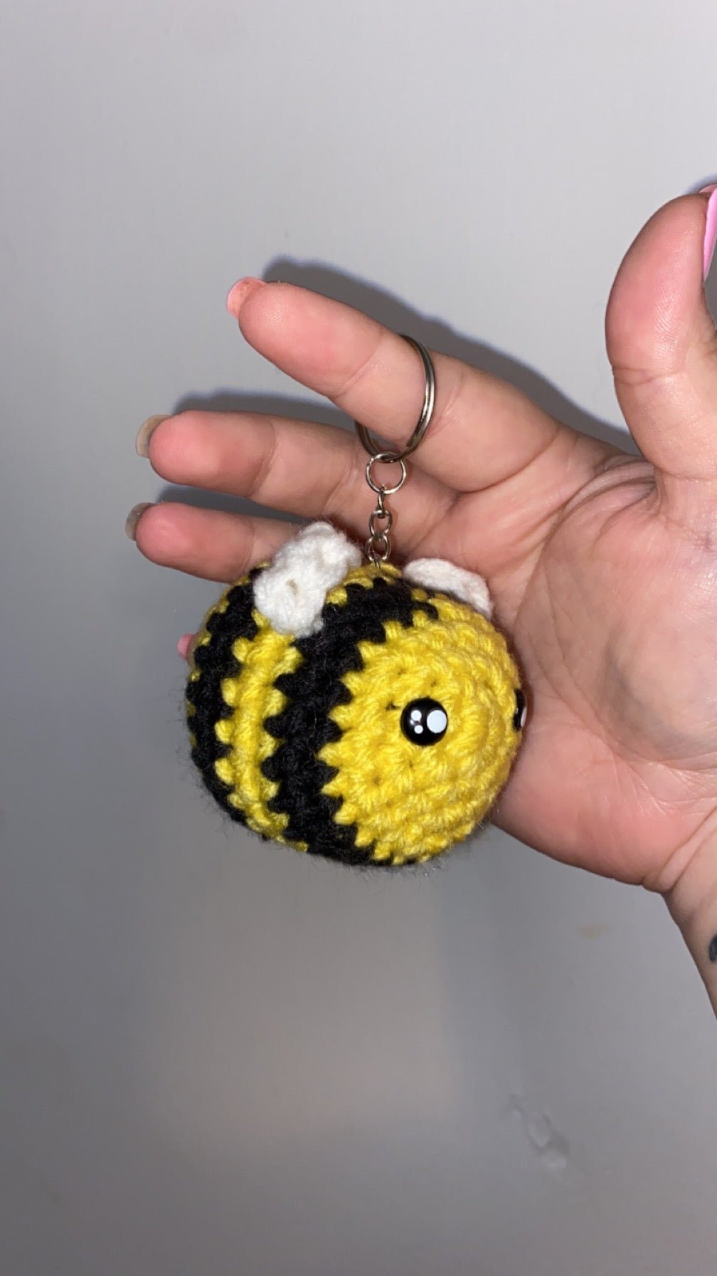Detailed crochet bee keychain with yellow and black stripes.