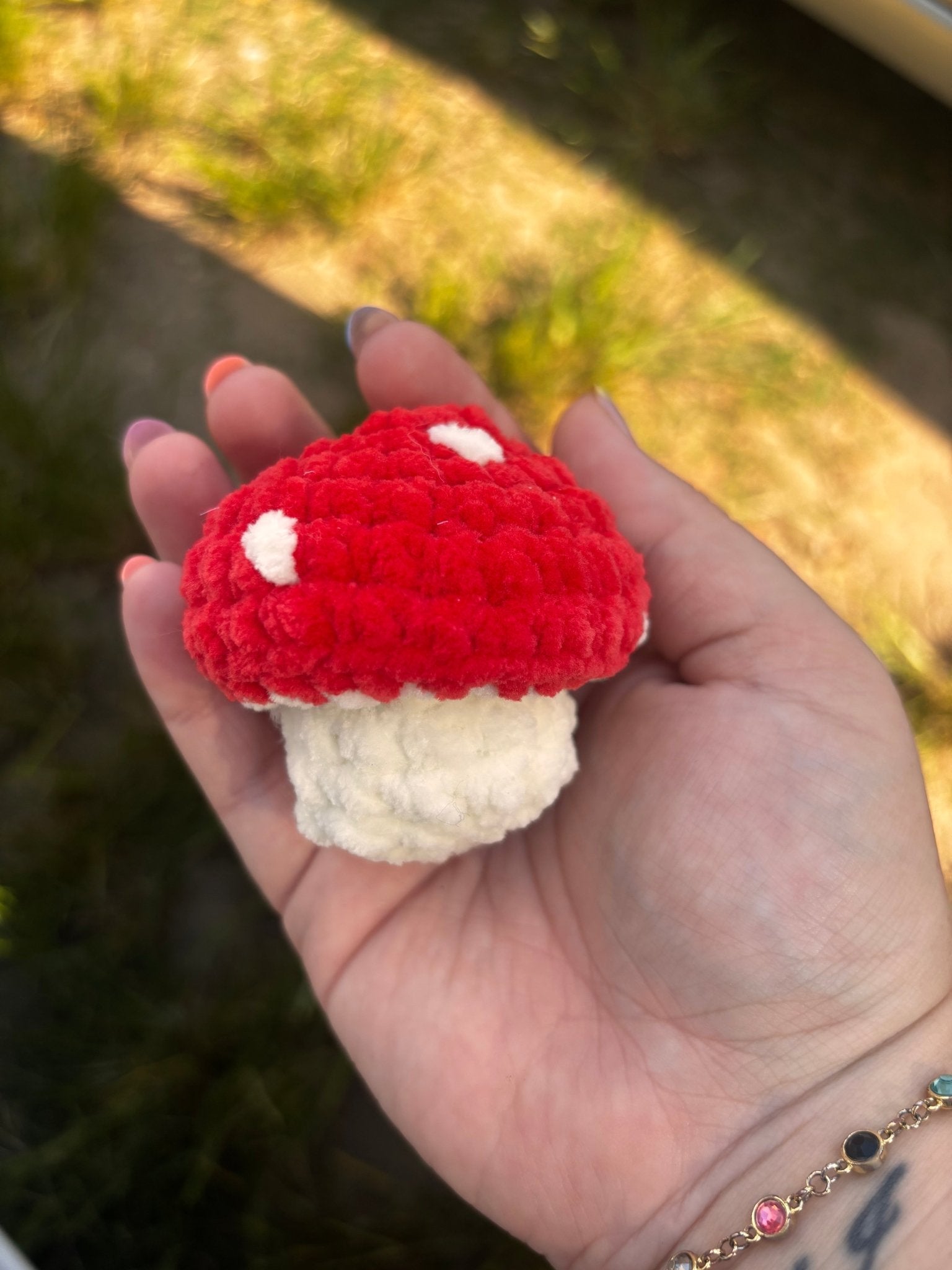 Main Street Collective's Popping Mushroom Crocheted Fidget Toy held in hand. Red & White Crochet Mushroom Toy.