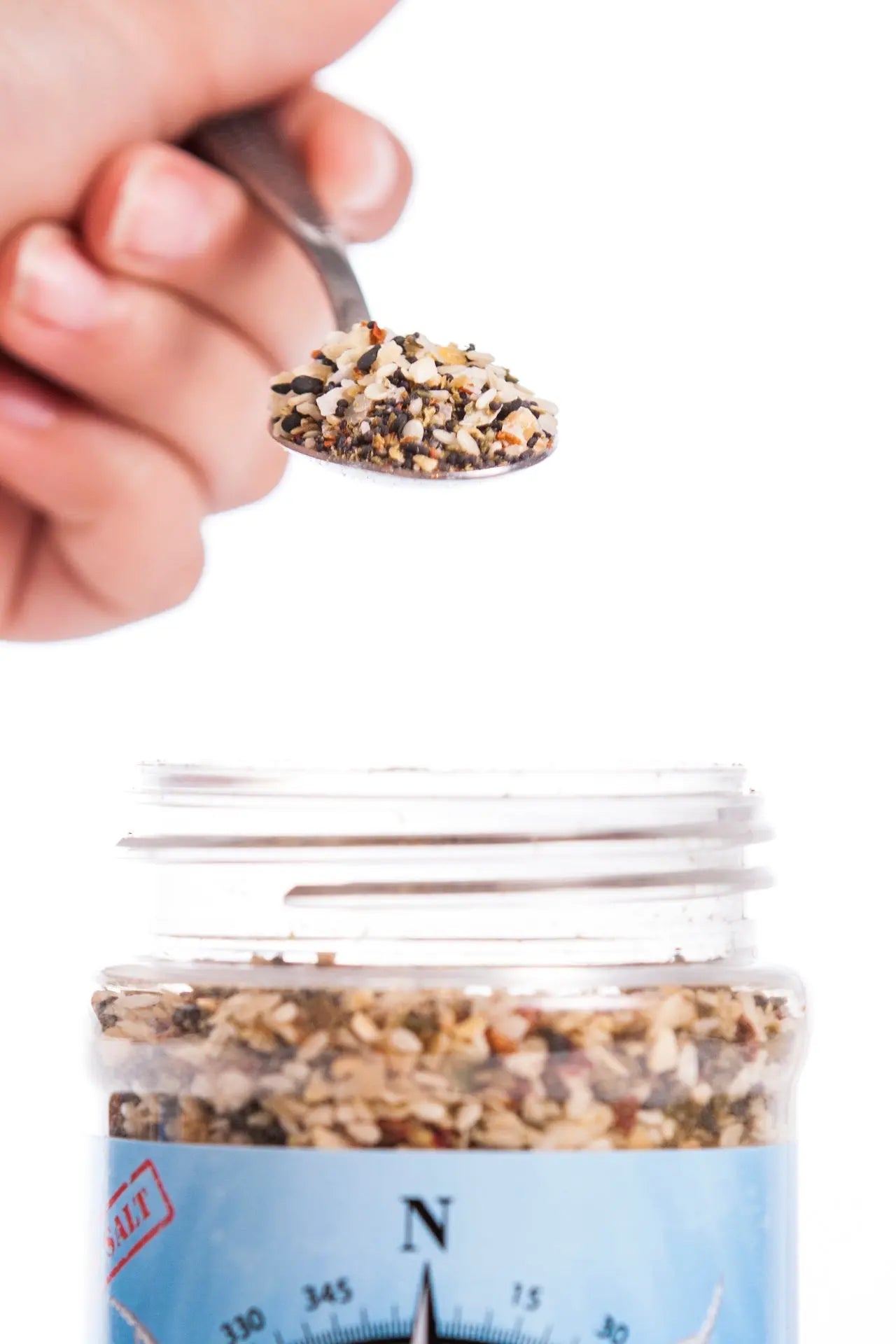 Everything Bagel Seasoning: Bayou Blend by Main Street Collective - Spoonful over a jar of flavorful spice blend.