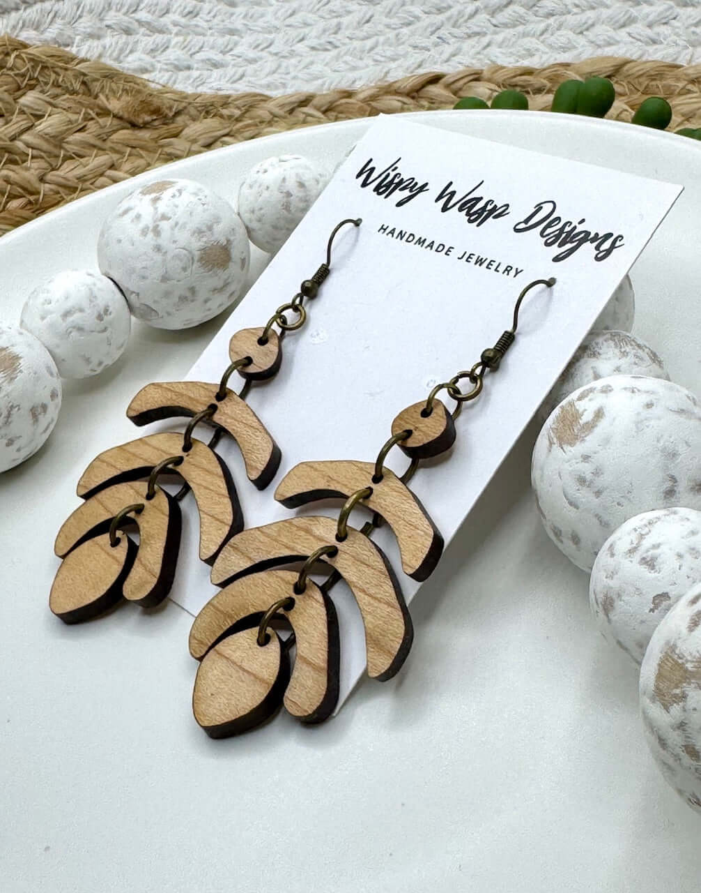 Handmade earrings – close-up of The Jet Earring by Wispy Wasp, highlighting natural cherry wood grain and brass stainless steel findings.