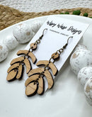 Handmade earrings – close-up of The Jet Earring by Wispy Wasp, highlighting natural cherry wood grain and brass stainless steel findings.