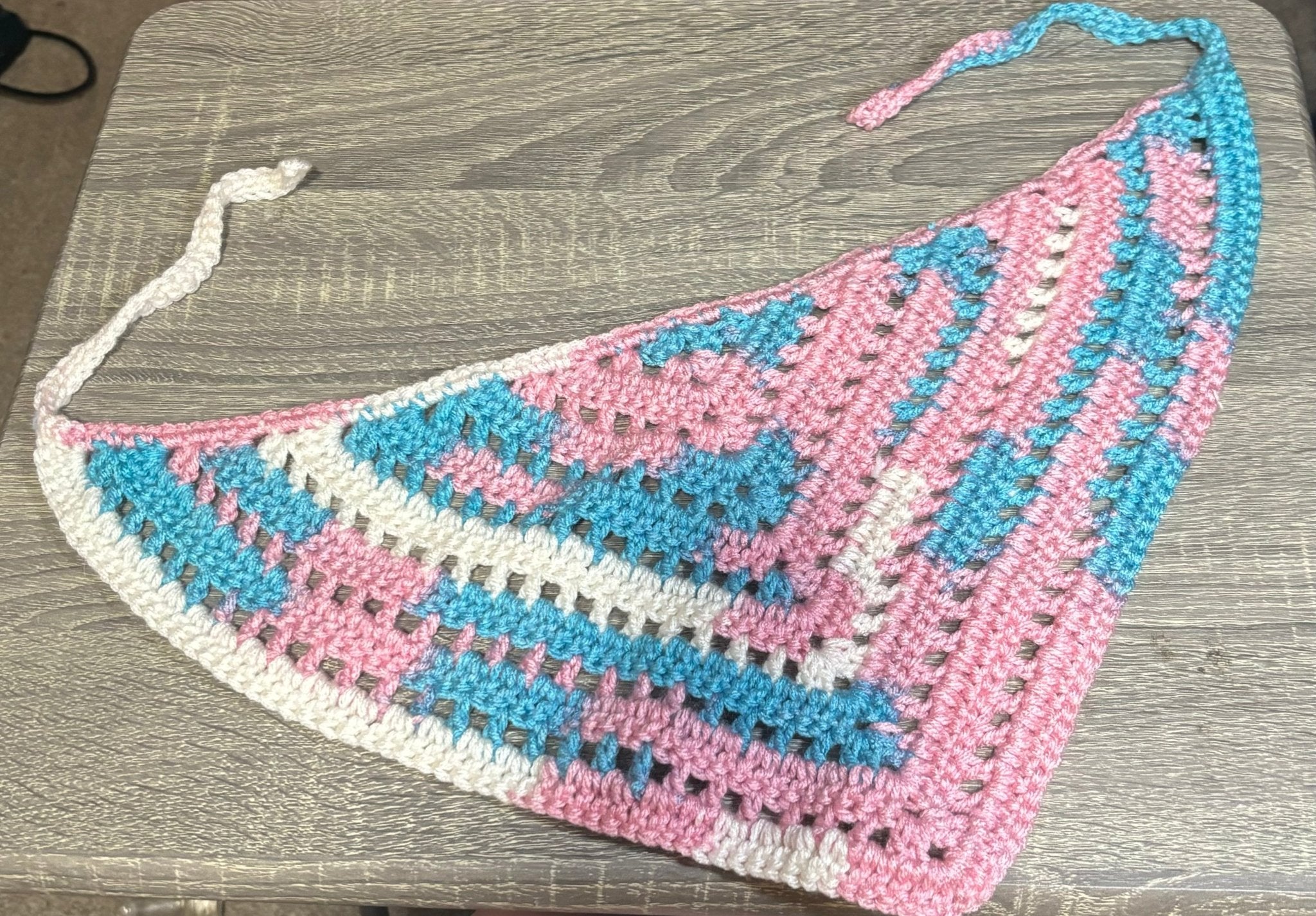 Handmade crocheted pride flag bandana with vibrant rainbow colors.