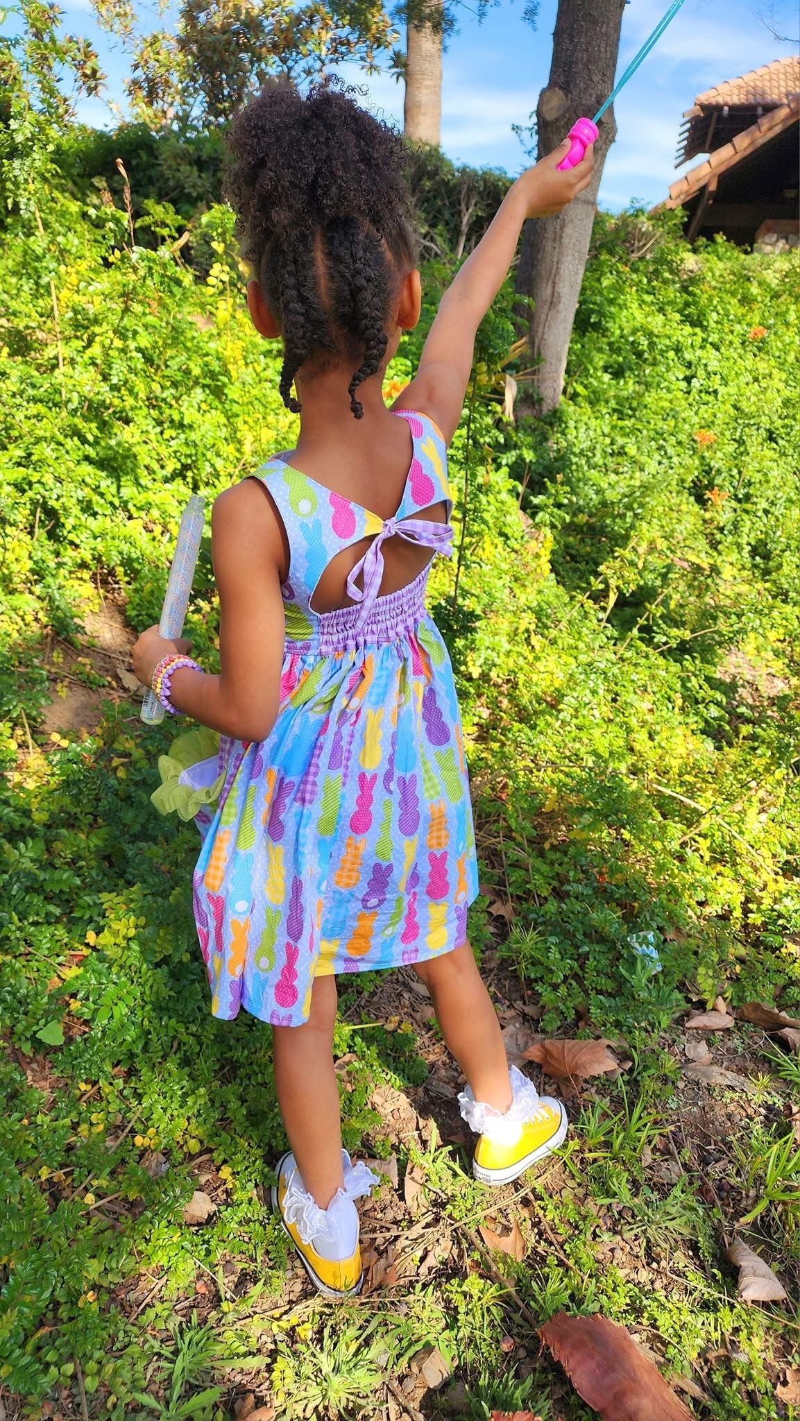 Girl in Easter Peeps Dress from Main Street Collective: Bunny, pockets, spring fashion for kids, toddler dress, back detail, yellow shoes.