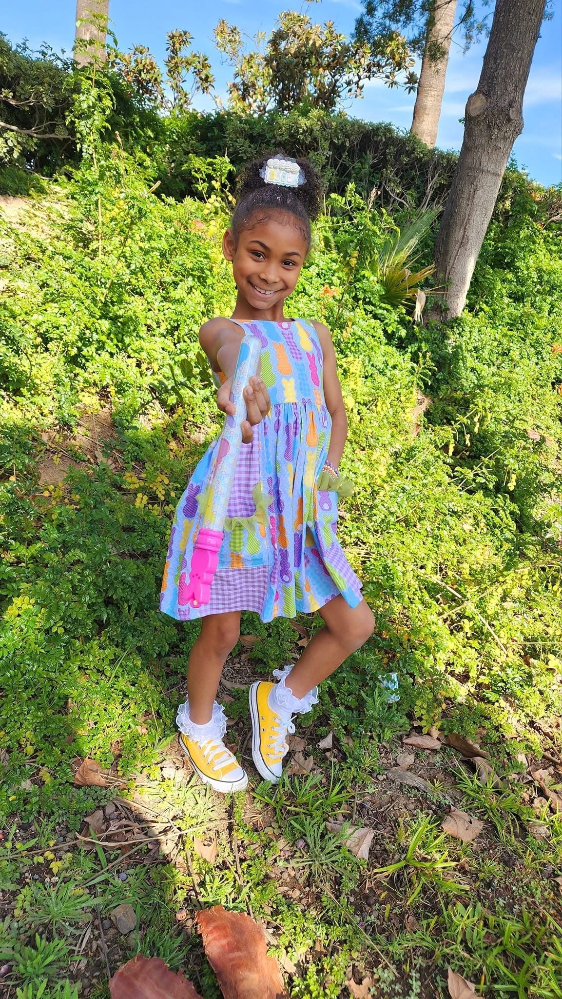 Cute girl in Easter Peeps dress and yellow sneakers playing outdoors by Main Street Collective. Perfect spring outfit!