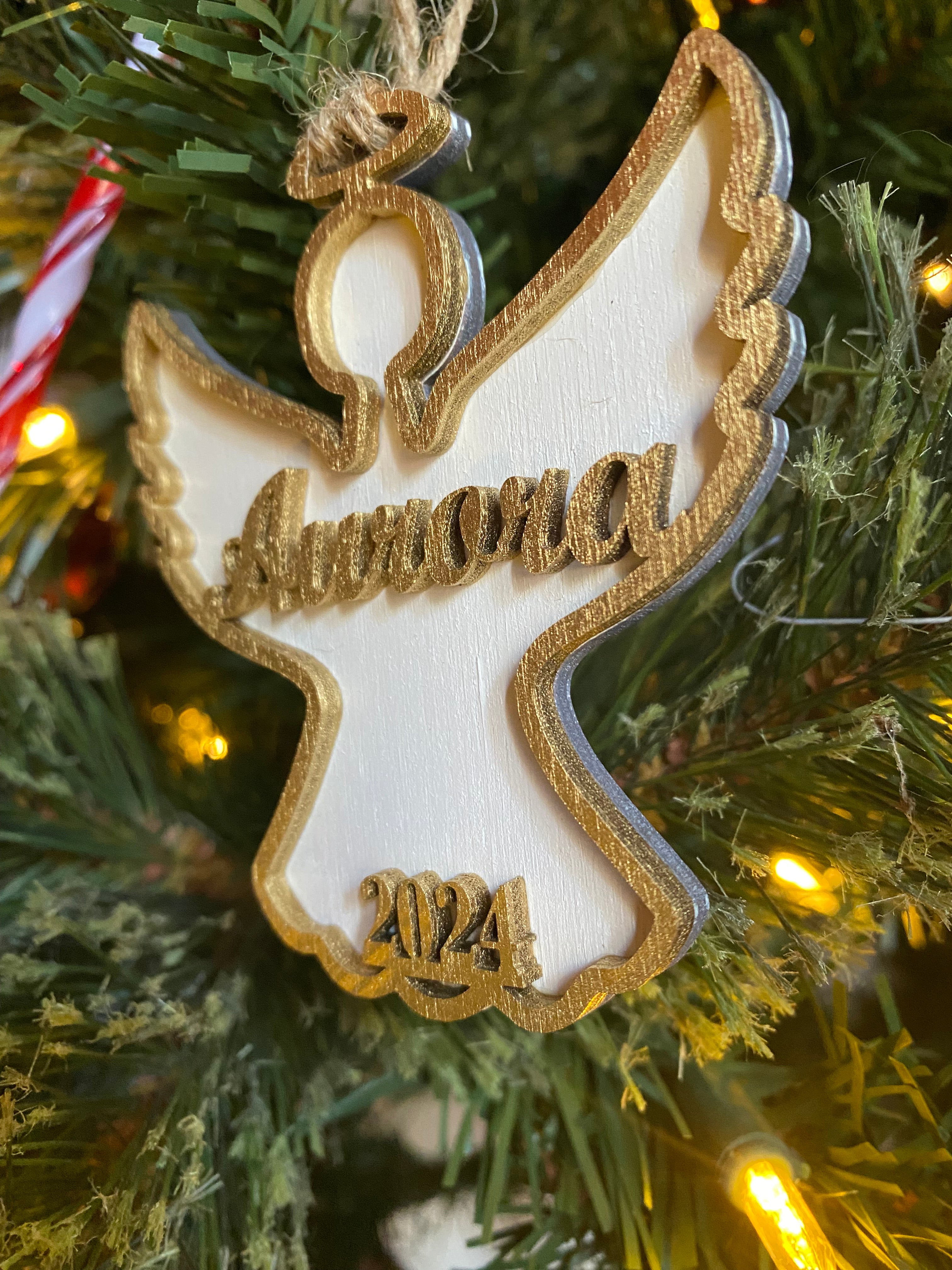 Personalized Angel Ornament 2024: Gold-edged wooden Christmas decoration with name, angel shape on tree.