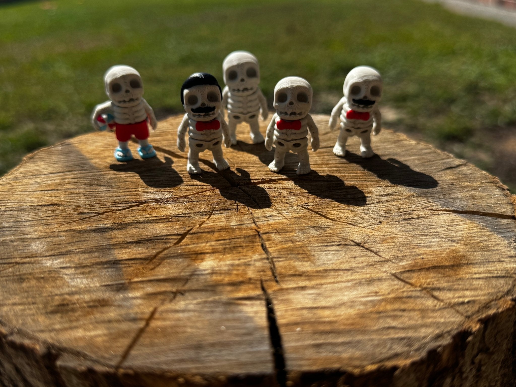 Main Street Collective: 3D Printed Skeleton Fidget Toys (Summer, Mustache, Bow-tie, Regular, Mister Skeleton) on Tree Stump