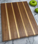 Mississippi handmade gift – angled photo of 13.5x10.5 sapele and maple cutting board by Faithful Woodworks, showing rich wood grain and handcrafted detail.