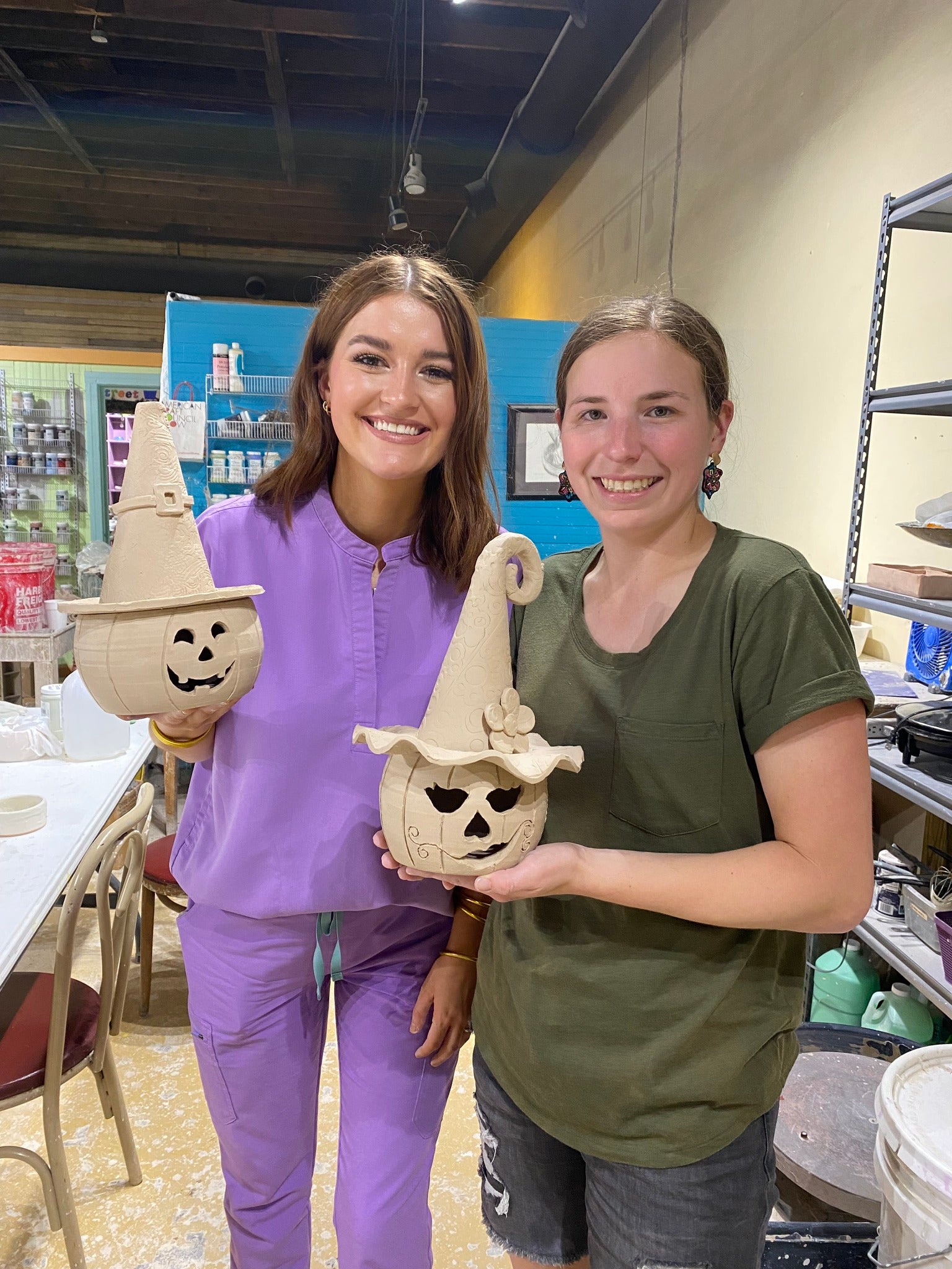 Pottery class fun! Women show off their DIY ceramic jack-o'-lanterns made at the 'Night of the Pumpkins' workshop, Main Street Collective.