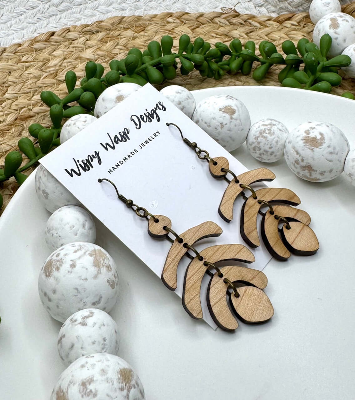 Rustic handmade earrings – The Jet Earring by Wispy Wasp displayed hanging, handcrafted in Mississippi from cherry wood.