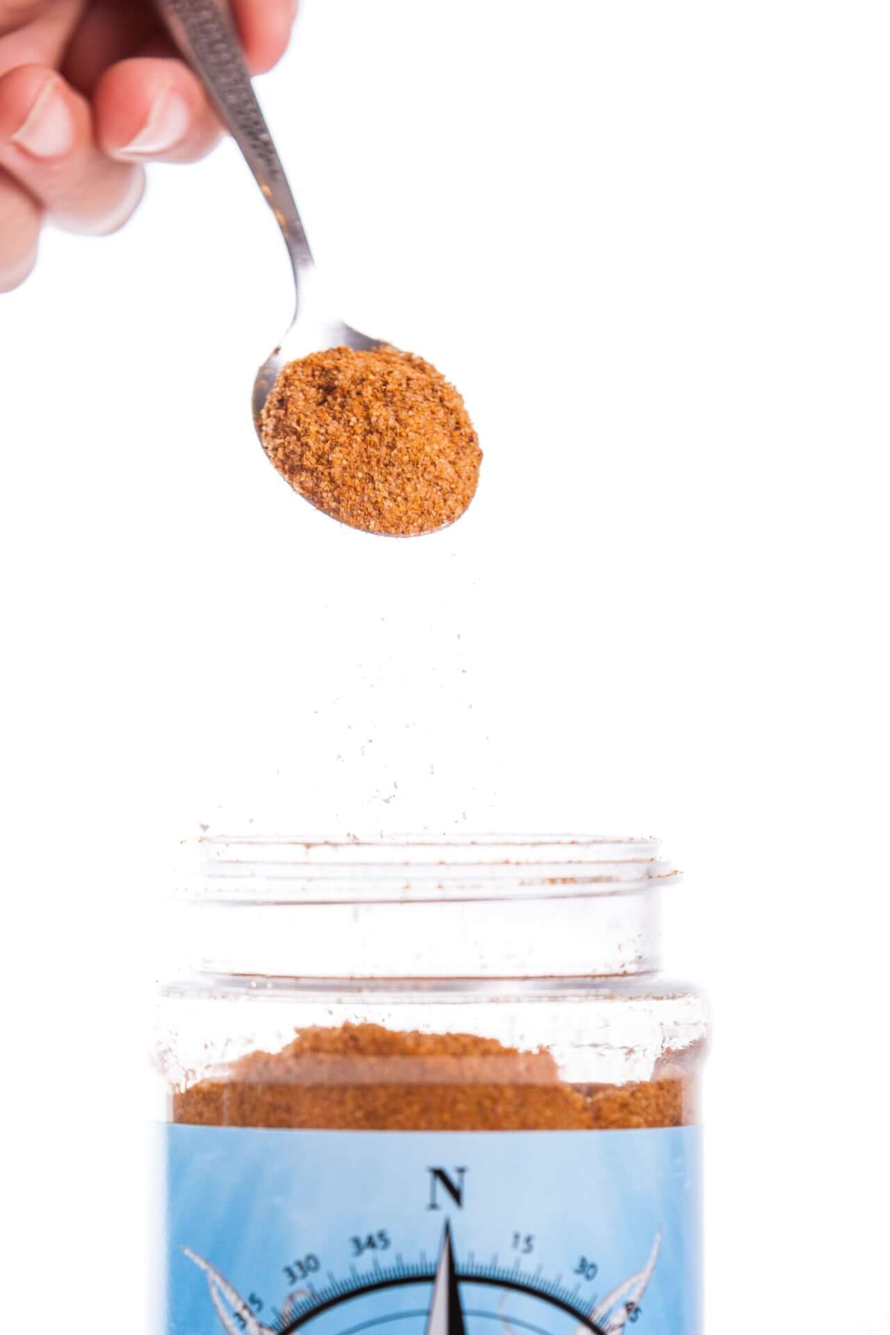 Compass Point Blends Seafood Boil Seasoning pouring into a Compass jar. Spice blend for seafood.