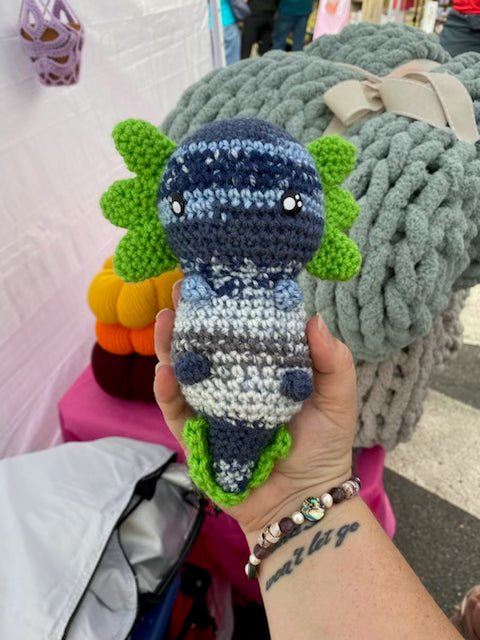 Soft handmade axolotl plush with colorful crochet gills and body.
