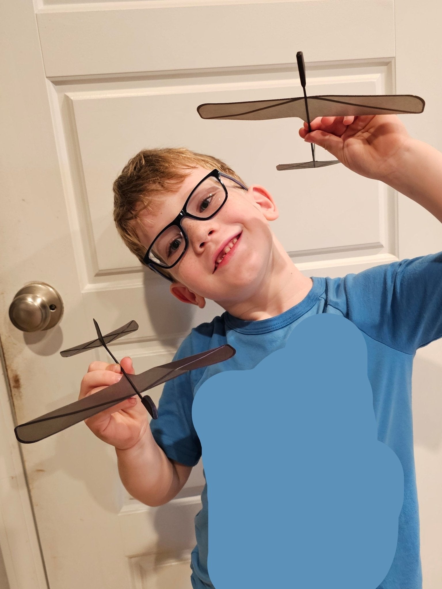 Child holding 3D printed Sky Soarer glider planes, ready for outdoor flight.

