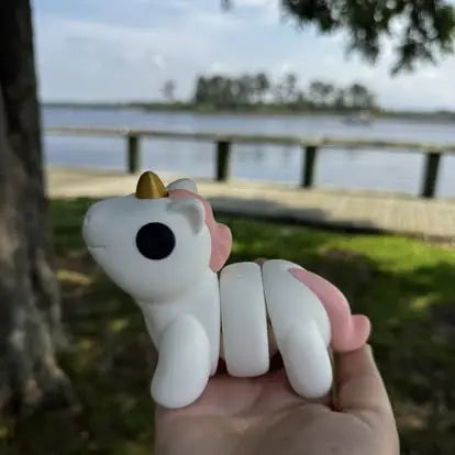 Unicorn Fidget Toy: 3D Printed, White & Pink Sensory Toy in Hand with River View