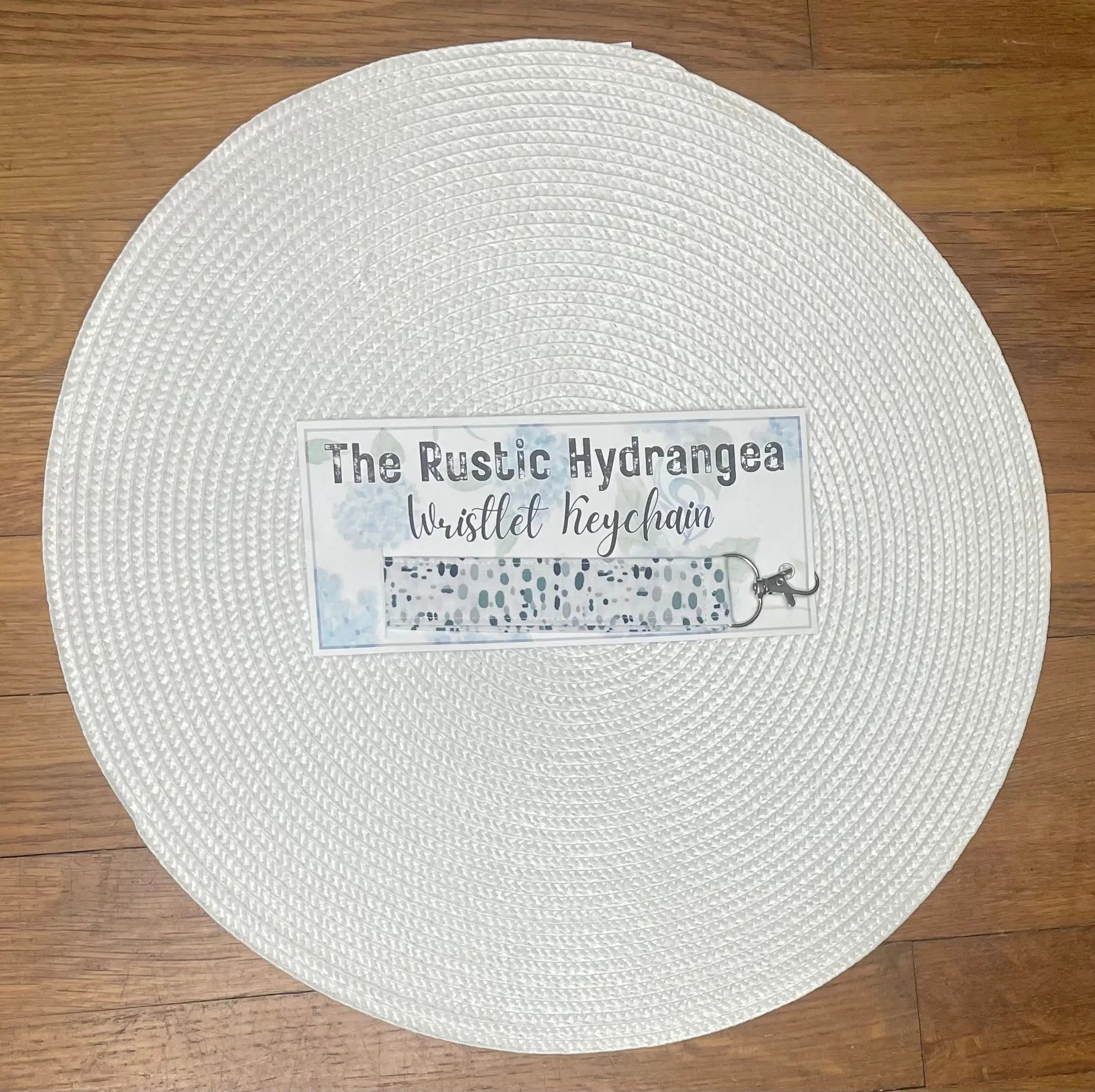 Rustic Hydrangea Wristlet Keychain: Fabric wrist keyholder with blue and white floral pattern. Main Street Collective product