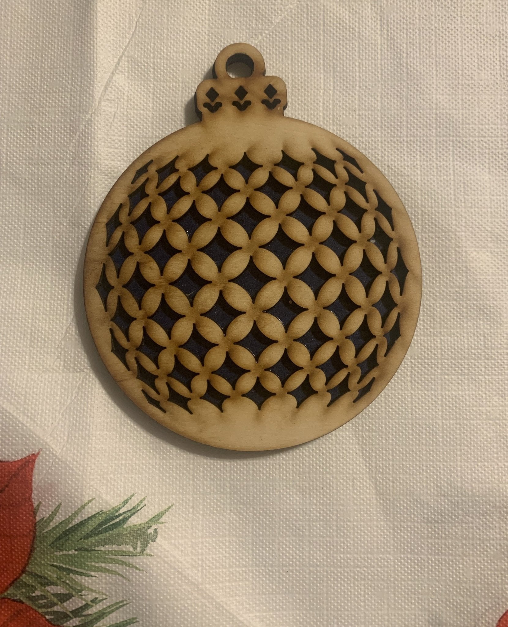 Wooden Christmas ornament with geometric cutouts.