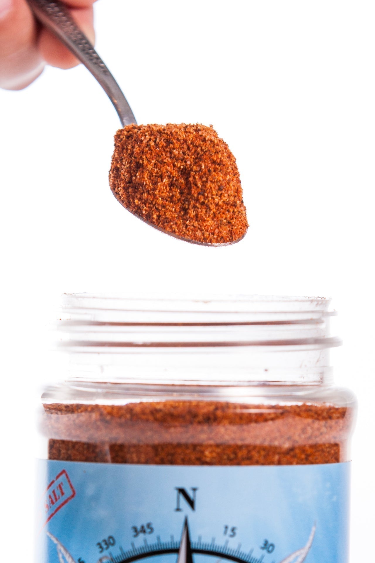 Compass Point Cajun Blend being spooned into jar. Low sodium seasoning.