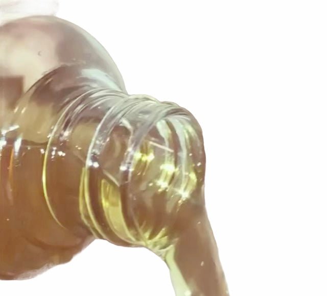 Pouring multi-use oil from bottle. Hair care by Main Street Collective. Lightweight formula for skin and hair.
