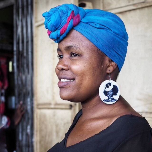 Black Woman with Blue Headwrap and Portrait Earrings by Betty Press