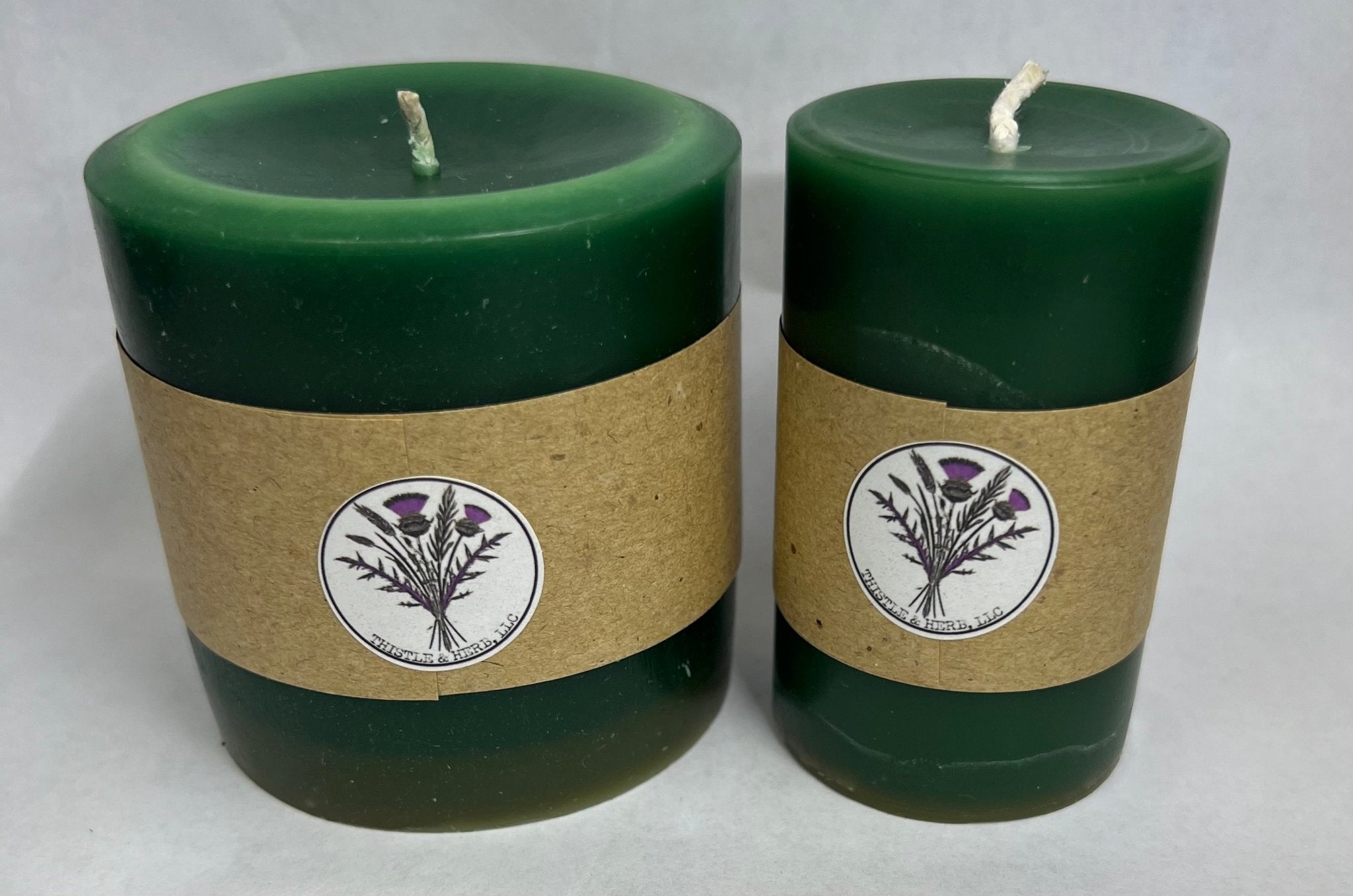 Two Green Beeswax Candles: Unscented, Cylindrical. Thistle Logo. Main Street Collective.