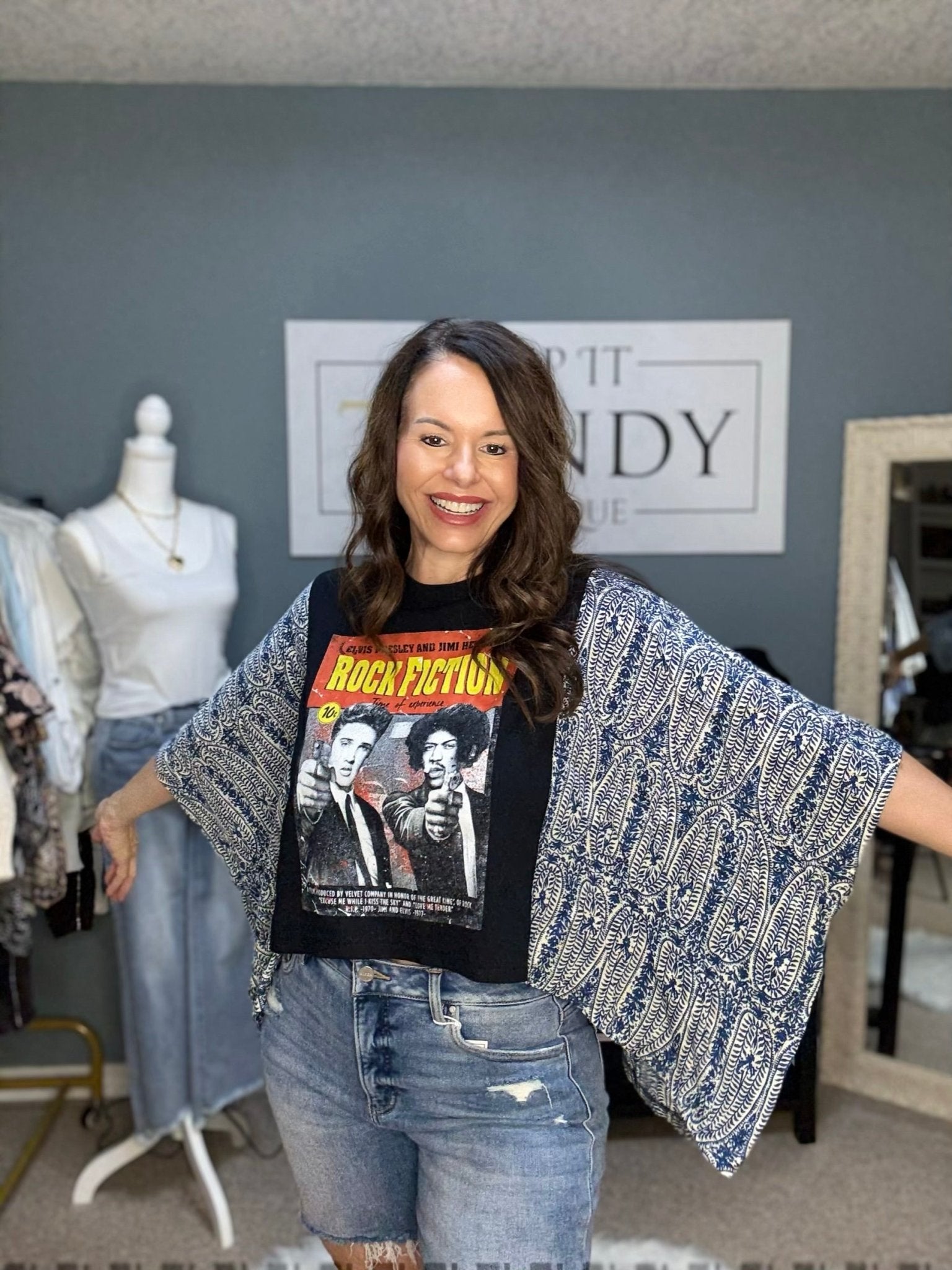Woman in Shannon Passero Elvis/Hendrix graphic tee with batwing sleeve cover up and jean shorts. Main Street Collective.