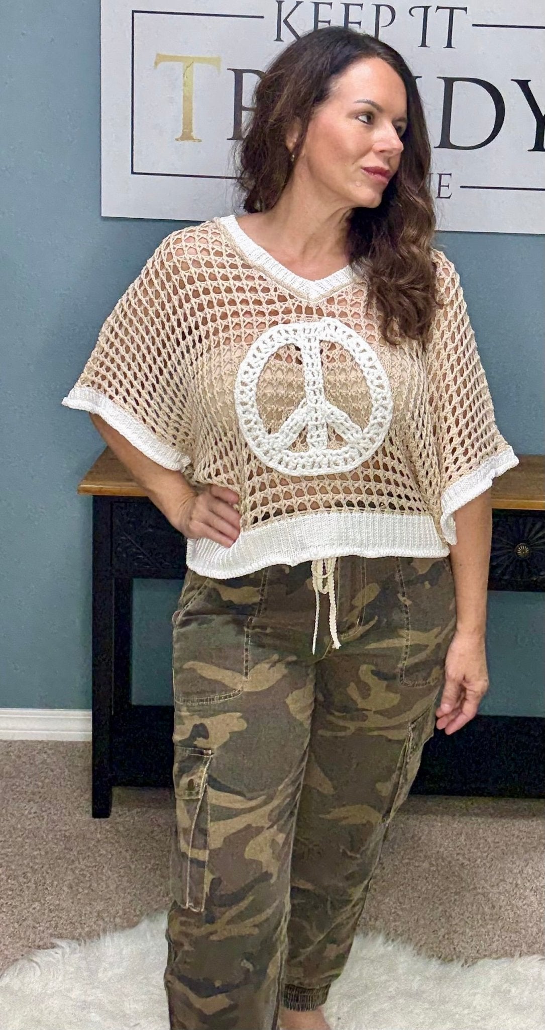 Woman in peace sign top and camouflage jogger pants from Main Street Collective. Fashionable and comfortable outfit.