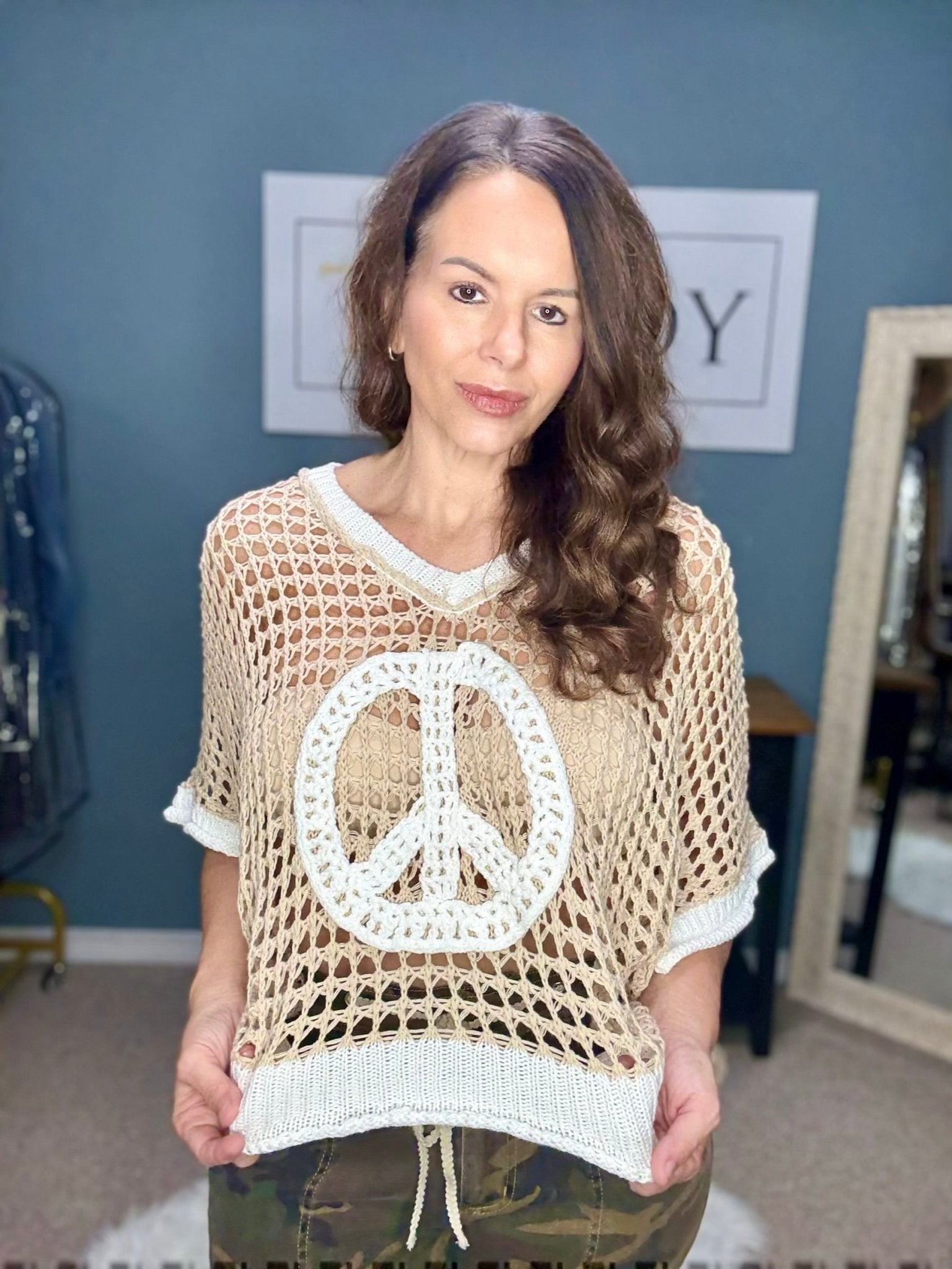 Woman in POL Open Crochet Peace Sign Sweater from Main Street Collective, Mississippi Boutique. Boho style oversized peach knit top.