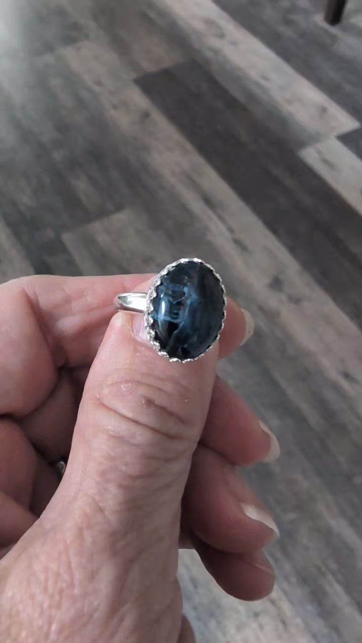 Video of handcrafted Pietersite ring by Solid Rock Jewelry showing the stone's mesmerizing play of colors and patterns as light moves across its surface.