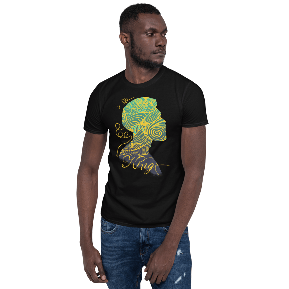 Man in black t-shirt with a "King" graphic design. Model with graphic tee and jeans on a green background.